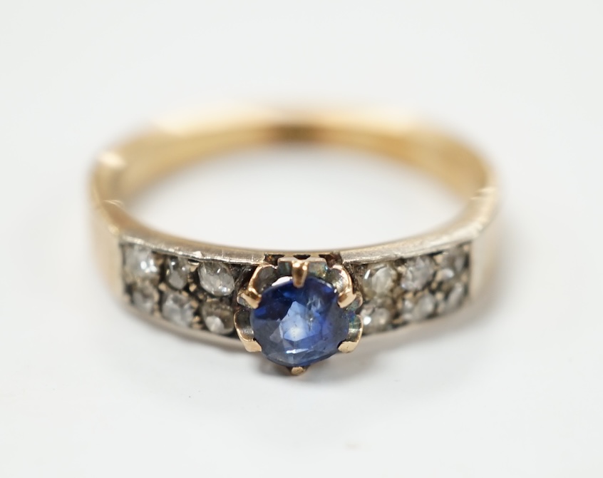 An early 20th century yellow metal (stamped 18) and single stone sapphire set ring, with twelve stone diamond chip set shoulders, size M, gross weight 3.2 grams. Condition - fair